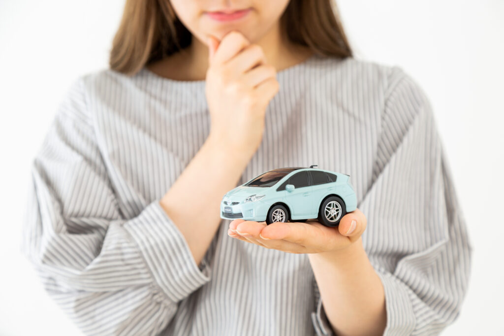 車の買い替え時期について悩む女性