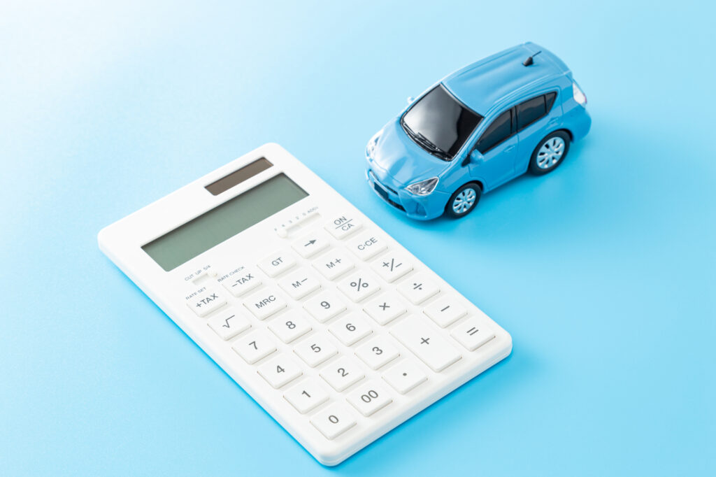 車と電卓の画像で車にかかる費用のイメージ